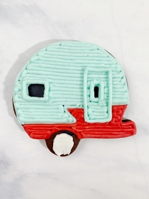 Fill in the bottom part of the Christmas camper cookie with the red frosting.