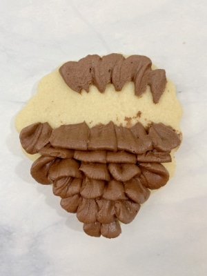 flip the cookie over to pipe the bottom part of the pine cone cookies