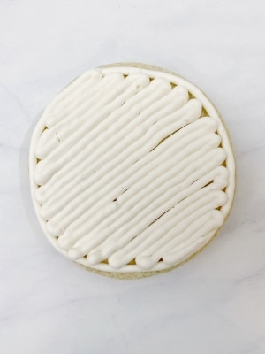 white buttercream piped onto cookie