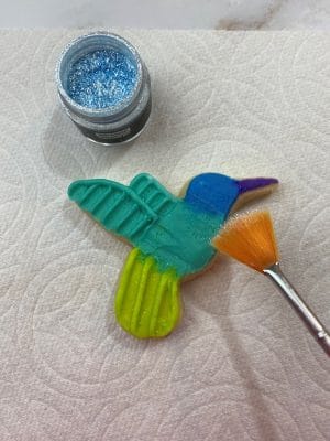 Use a fan brush to tap Fancy Sprinkles Prism Powder onto the hummingbirds.
