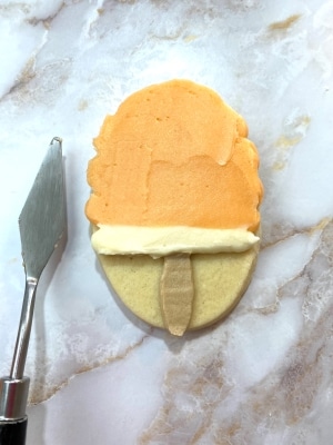 orange flavored buttercream on creamsicle cookie, smoothed with palette knife
