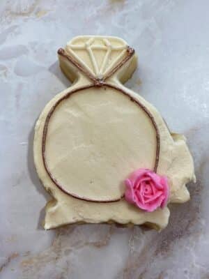 piping a rose onto the engagement sugar cookies