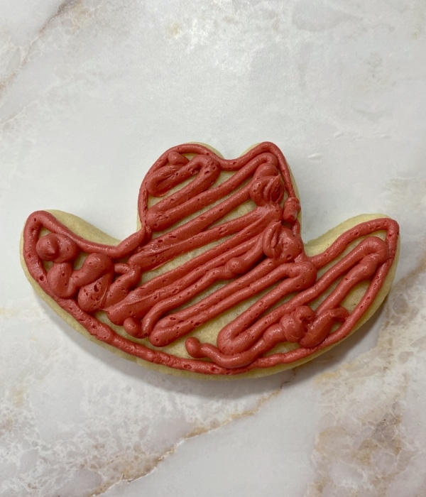 rust red buttercream on cowboy hat cookie
