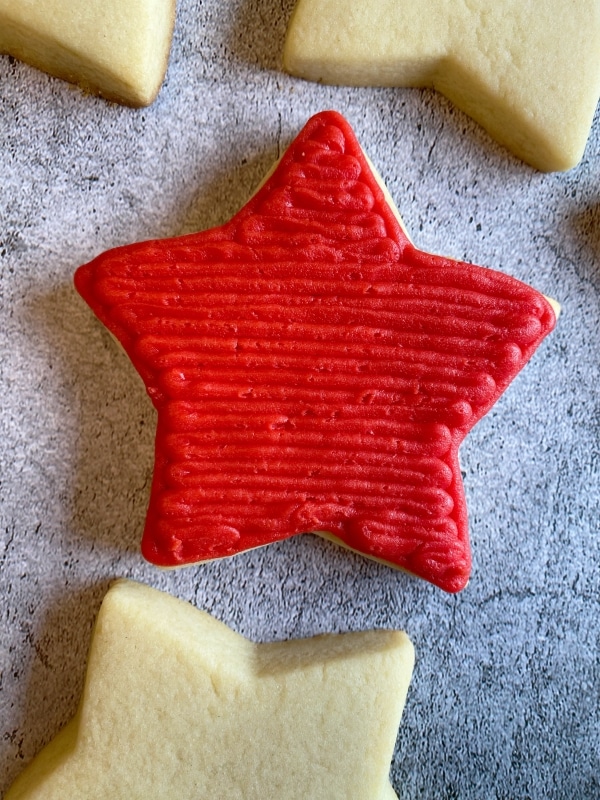 red buttercream frosting on star cookie