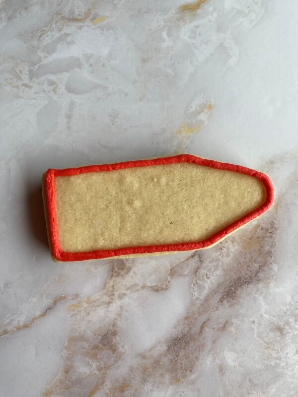 outline crayon sugar cookie with red buttercream